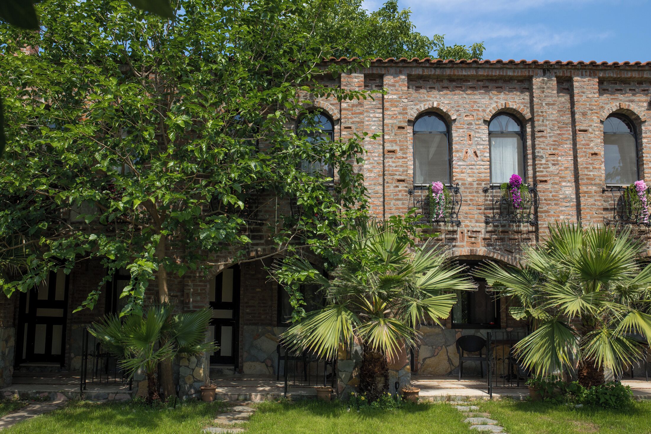 Un edificio de ladrillo con ventanas de arco y una entrada de piedra.