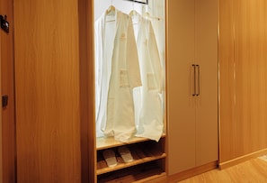 A wooden wardrobe with a hanging shoe rack and a pair of slippers.