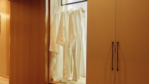 A wooden wardrobe with a mirror, a hanging robe, and a shelf with slippers. - Europa  (Semey)