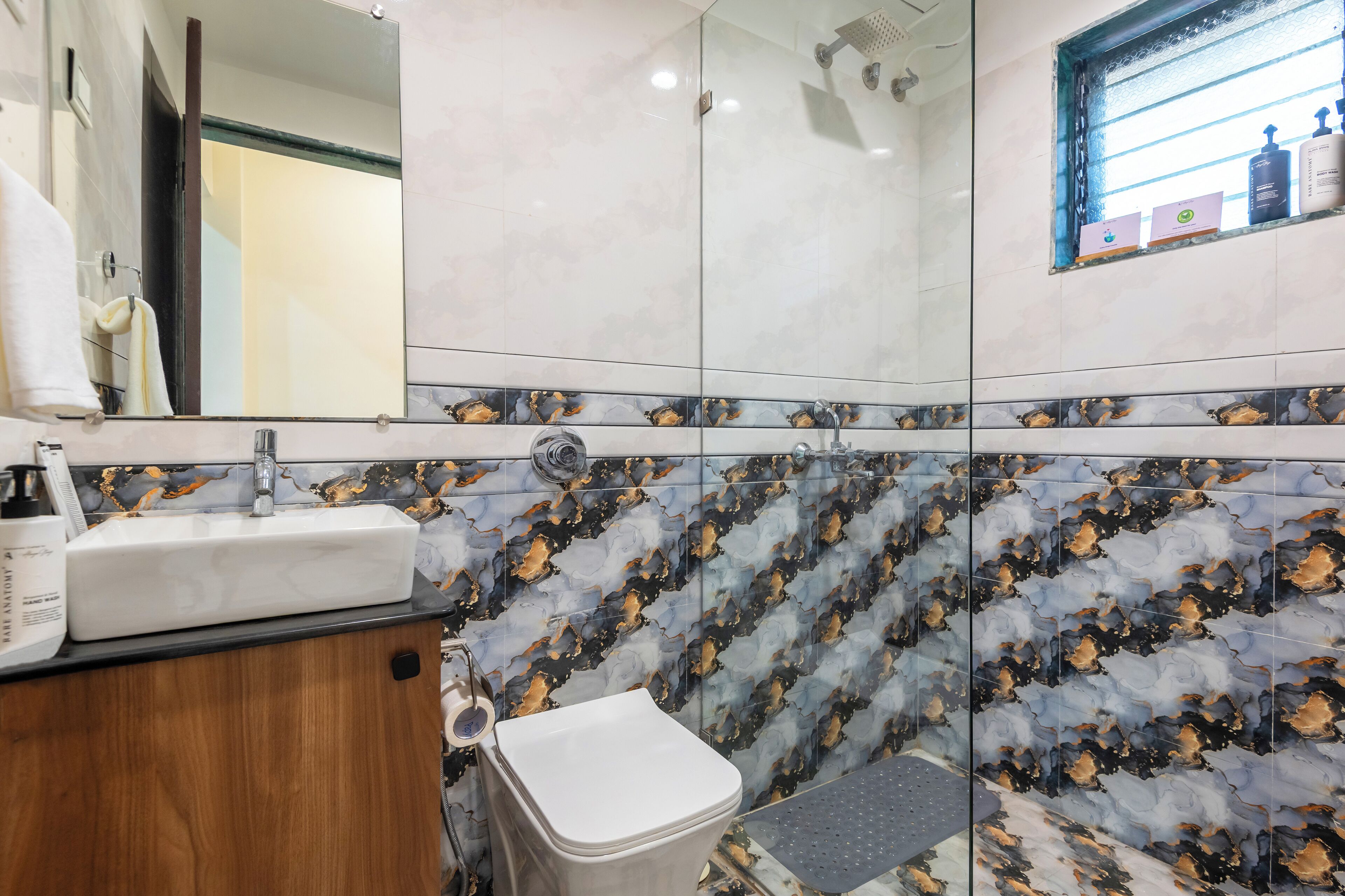 Un baño con lavabo, espejo y ducha.