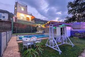 A modern house with a swimming pool, outdoor seating, and a covered patio. - Ansh Villa Luxury 4-BHK Pet-friendly (Jambrung)
