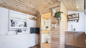 Eine moderne Küche mit Holzwänden, einem integrierten Fernseher und einem Fischgrätparkett.