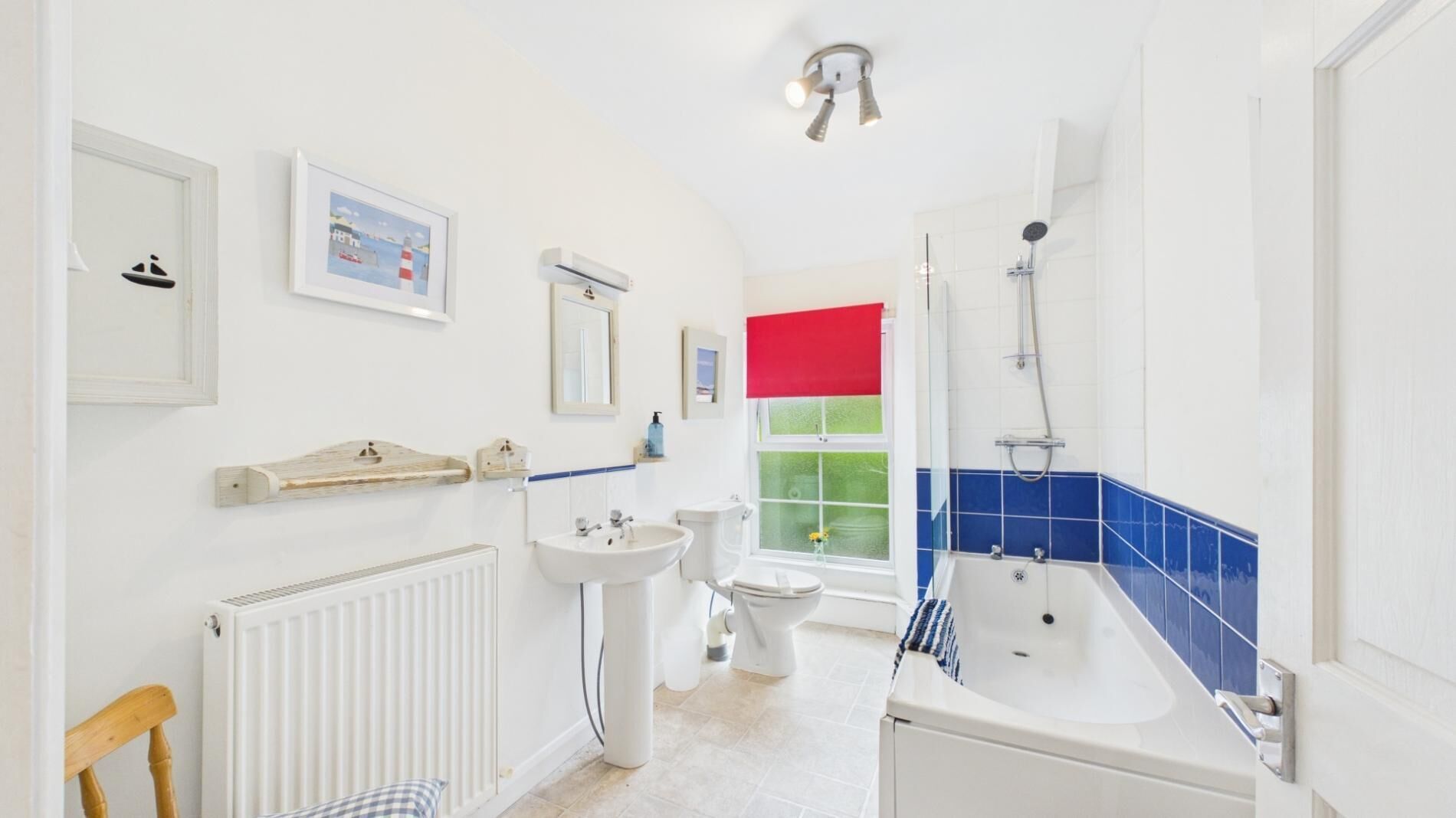 A bathroom with a radiator, sink, toilet, and bathtub.
