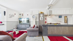 Ein modernes Wohnzimmer mit einem Flachbildfernseher, einer Uhr und einem roten Teppich.