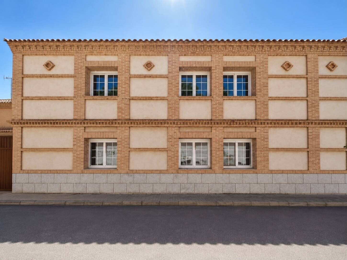 A two-story building with a symmetrical facade, featuring evenly spaced windows and decorative elements.