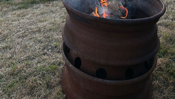 A rustic outdoor setting with a fire pit, a dog, and a sunset in the background. - Daisys Meadow Retreat Sleeps 2 With Hot Tub (Ashford)
