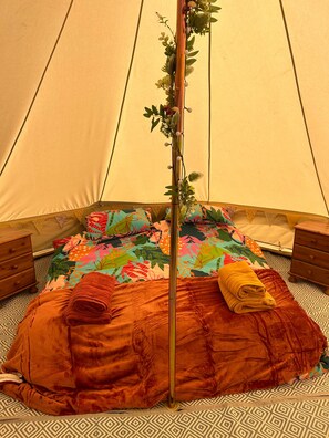A tent with a bed, pillows, and a blanket. - Daisys Meadow Retreat Sleeps 2 With Hot Tub (Ashford)