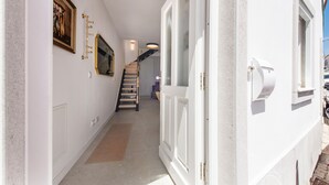 A hallway with a staircase, a door, and a wall-mounted picture frame. - Casa Portuguesa in Tavira (Tavira)