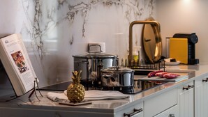A kitchen with a marble backsplash, stainless steel appliances, a book on a stand, and a pineapple on the counter. - Casa Portuguesa in Tavira (Tavira)