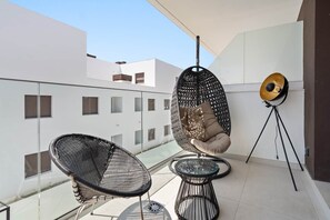 A balcony with two wicker chairs, a hanging chair, and a floor lamp. - RDR513 - Beautiful 1 Bedroom Apt. in Atica Homes Estepona (Estepona)