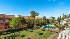 A resort with a swimming pool, palm trees, and a well-maintained lawn. - RDR548 - Stylish 2 bed apt in La Ola (Marbella)