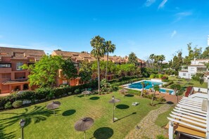 A resort with a swimming pool, palm trees, and a well-maintained lawn. - RDR548 - Stylish 2 bed apt in La Ola (Marbella)