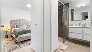 Ein modernes Schlafzimmer mit Bett, Nachttisch und Beistelltisch.