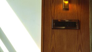 Una pared de madera con una lámpara y un interruptor.