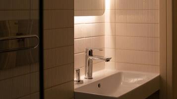 A bathroom with a white sink, a mirror, and a towel rack.