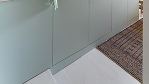 Eine Küche mit Kupfergeschirr, einem Spülbecken und einem Holzbalken an der Decke.