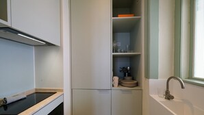 Uma cozinha compacta com forno embutido, pia e janela.