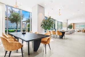 A modern conference room with a large table, comfortable chairs, and large windows offering a view of the cityscape. - FIRST CLASS 2BR Next to Burj Khalifa & Dubai Mall (Downtown)