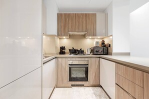 A modern kitchen with a built-in oven, a gas stove, and a toaster. - FIRST CLASS | 1BR | Contemporary Meydan Living (Meydan)