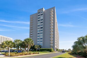 A tall hotel with multiple balconies, surrounded by palm trees and a well-maintained lawn. - $150 Free activities - E-gift card when you book- On the ocean | SH105 (Myrtle Beach)