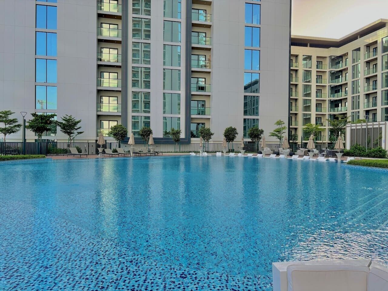 Una piscina con un edificio moderno al fondo.