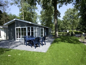 A modern building with a patio, a table with chairs, and a lawn. - Holiday Home in Arnhem With Terrace (Arnhem)