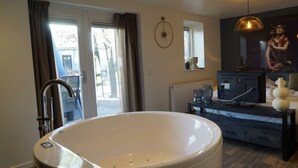 A modern bathroom with a freestanding bathtub, a sink, and a vanity. - Comfort Room Deluxe 2 (Otterlo)