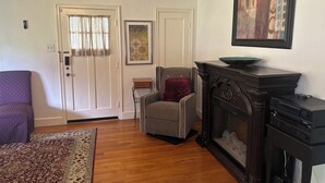 A living room with a fireplace, a sofa, a chair, and a rug. - Spacious, Cozy and Quiet 3 Bedrooms and 2 Bathrooms Located 12 min to downtown (Savannah)