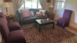 A living room with a leather sofa, patterned cushions, a coffee table, and a patterned rug. - Spacious, Cozy and Quiet 3 Bedrooms and 2 Bathrooms Located 12 min to downtown (Savannah)