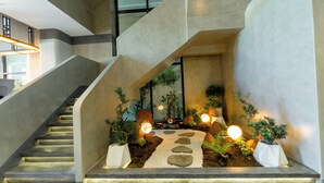 A modern staircase with a geometric design, surrounded by potted plants and decorative lighting. - Le Blend Residence  (Ou Chrov)