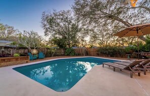 A swimming pool with lounge chairs and a sun umbrella. - Private pool near 8 minutes to Indian Rocks Beach (Largo)