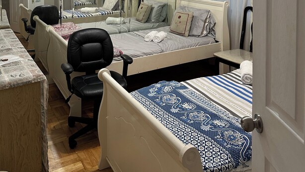 Hotelkamer met een groot bed, een bureau, een stoel, een spiegel en een plafondlamp.