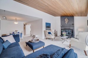 Uma sala de estar moderna com lareira, televisão e área de jantar.