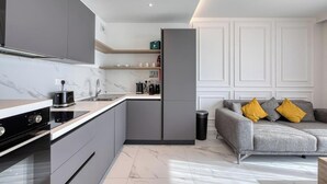 Una cocina moderna con horno empotrado, cafetera y lavaplatos.