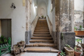 A staircase leading to a higher level, flanked by stone walls and potted plants.