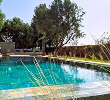 Una piscina al aire libre de temporada, sombrillas