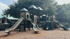 Ein Spielplatz mit mehreren Rutschen und Klettergerüsten.