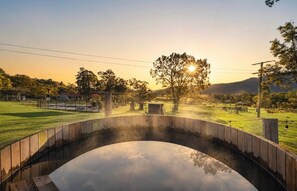 A bridge over a calm body of water with a clear reflection, surrounded by greenery and a distant mountain. - Glen Eden Estate - Entire Estate (Broke)