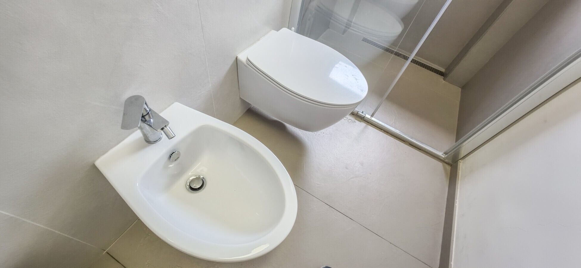 Un baño con bidé, inodoro y zona de ducha.