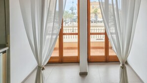 Ein Zimmer mit Blick durch eine Holztür, einer weißen Wand und einem Holzschrank.