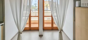 A room with a view through a wooden door, a white wall, and a wooden cabinet. - Il Vico 1 - Pozzallo (Pozzallo)