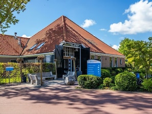 A building with a red-tiled roof, a signboard with EuroParc logo, and a paved entrance area with benches. - Holiday Home in Velsen-zuid With Terrace (Velsen-Zuid)