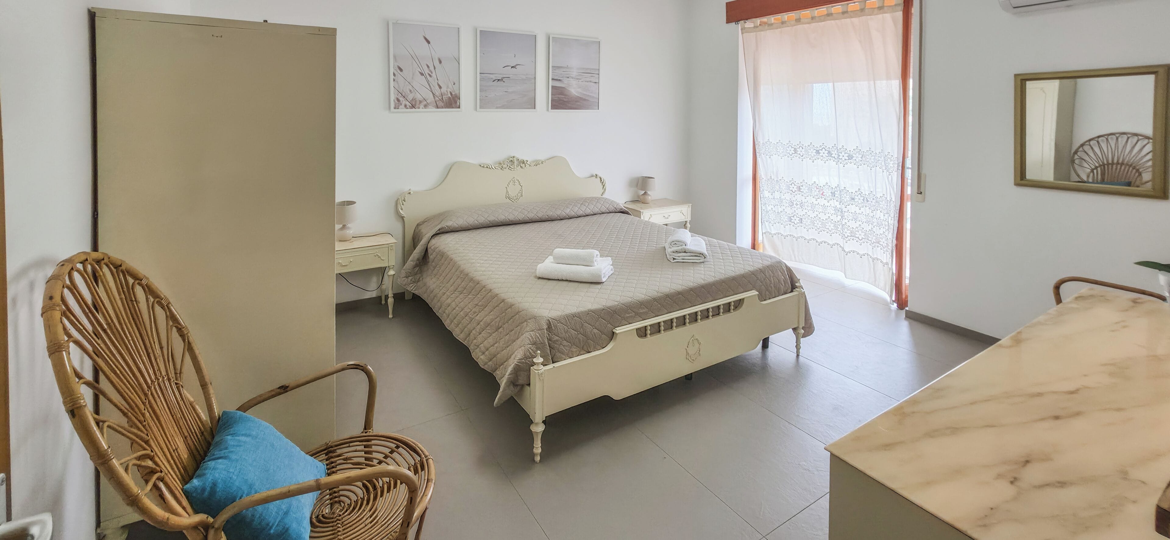 Ein Schlafzimmer mit Bett, Stuhl, Tisch und Kleiderschrank.