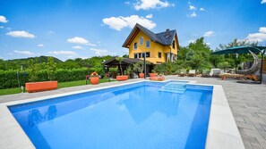 Ein Schwimmbad mit einem Haus im Hintergrund.