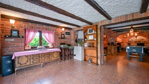 Une cuisine rustique avec des murs en briques apparentes, des poutres en bois et une cheminée en briques.