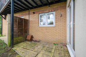 A brick house with a window, a wooden fence, and a door. - Heathrow Living 2BDR 2BA Apt 03-360stays (Stanwell)