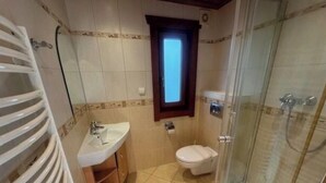 A bathroom with a shower, toilet, sink, and a small window. - Holiday Home in Susteren With Terrace (Susteren)