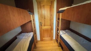 A narrow room with two bunk beds, a wooden door, and a wooden floor. - Holiday Home in Susteren With Terrace (Susteren)
