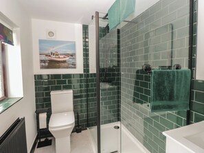 Ein Badezimmer mit Duschkabine, Toilette und Waschbecken.