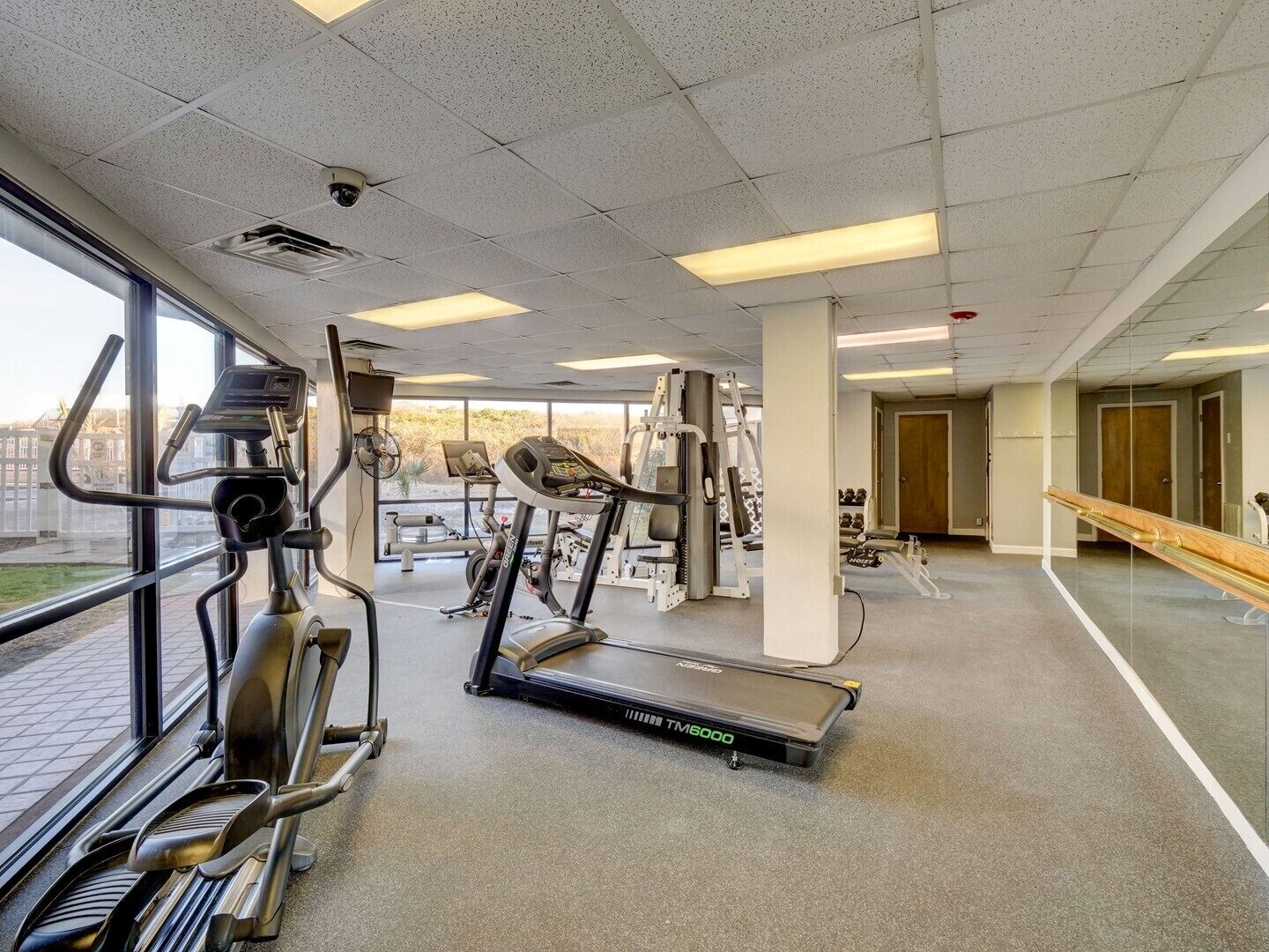 Une salle de sport équipée de tapis de course, de vélos elliptiques et de matériel de musculation.